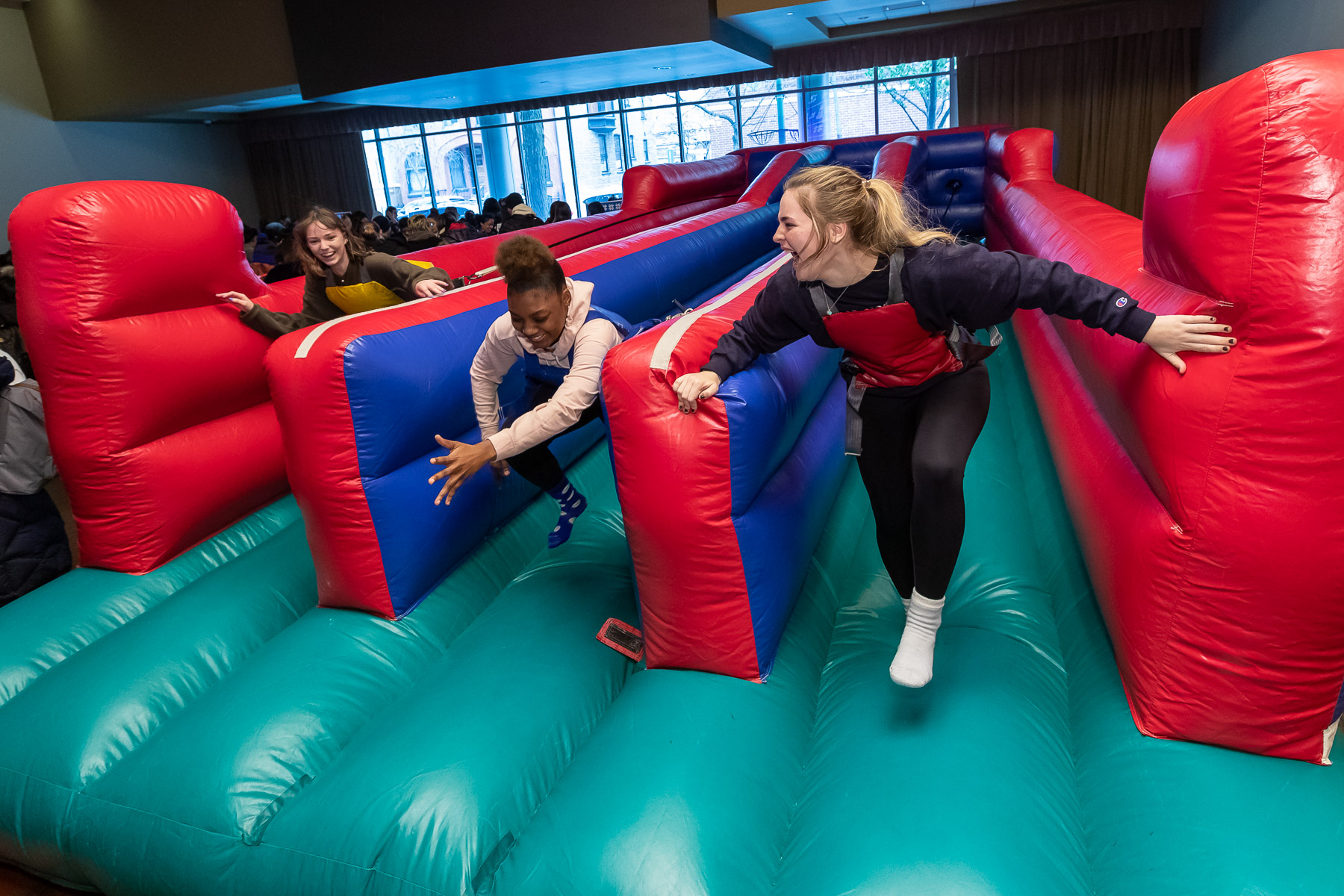 Students attempt to run against tethered harnesses in an inflatable bounce attraction in the Student Center. (DePaul University/Jeff Carrion)